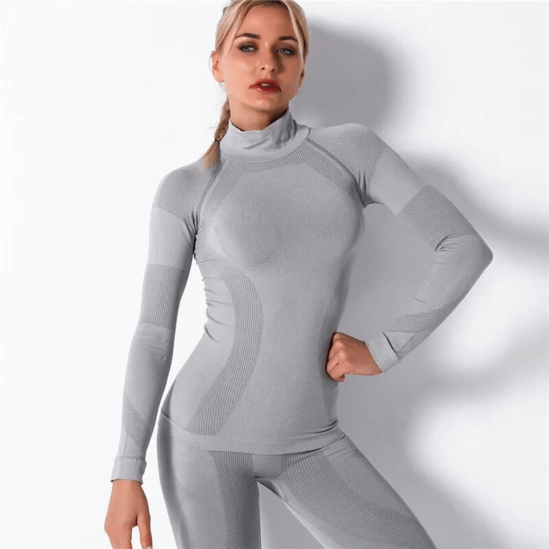 Woman wearing a grey stretchy seamless long sleeves top designed for sports, highlighting the soft, breathable nylon fabric and athletic fit.